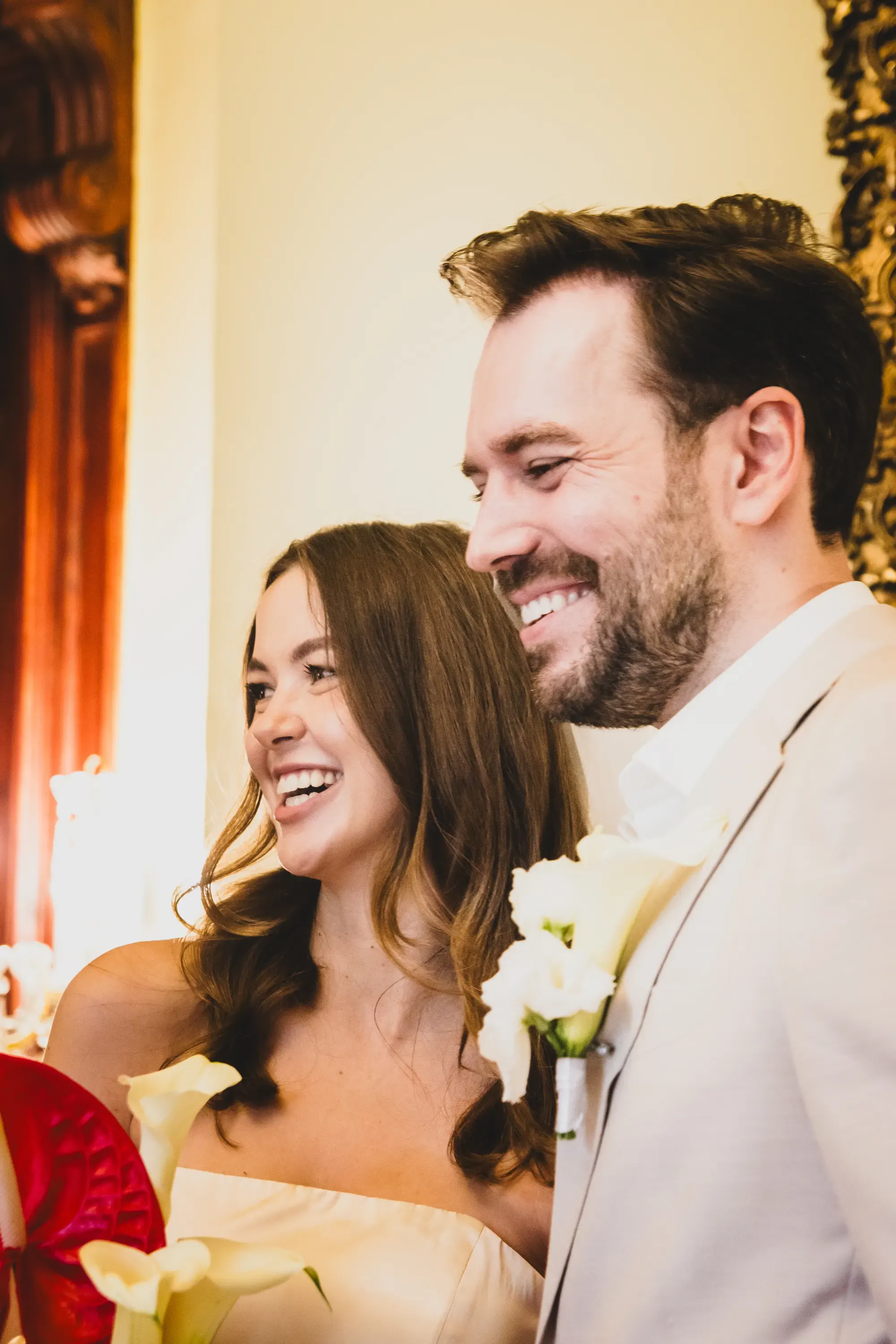 Lachendes Brautpaar bei der Zeremonie, Calla-Strauß im Vordergrund – Hochzeitsfoto